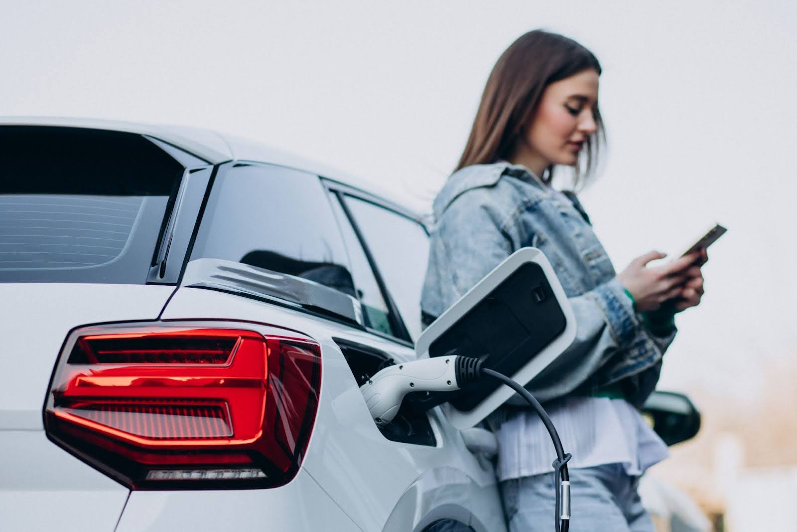 Mujer cargando su auto híbrido Kia en Panamá.